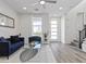 Living room featuring light grey floors, blue sofa, modern glass coffee table, and bright lighting at 108 Kimberlite Dr, Henderson, NV 89011