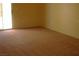 Bedroom with neutral carpet and light yellow walls, and a sliding glass door at 108 Zenith Point Ave, North Las Vegas, NV 89032