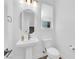 Modern bathroom with pedestal sink, toilet and round mirror at 11713 Redwood Mountain Ave, Las Vegas, NV 89138