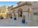 Covered back patio with archways, desert landscaping, and blue potted plants at 11908 Love Orchid Ln, Las Vegas, NV 89138