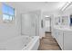 Bathroom featuring a tub, glass shower, and double vanity sinks at 11908 Love Orchid Ln, Las Vegas, NV 89138