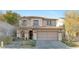 Charming two-story home with a tile roof, and a well-manicured front yard at 11908 Love Orchid Ln, Las Vegas, NV 89138