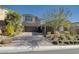 Charming two-story house featuring a manicured front yard, with a brick-paved driveway leading to a two-car garage at 12 Hilltop Crest St, Henderson, NV 89011