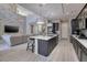 A modern, open kitchen flows into the living room, featuring a large island and stainless steel appliances at 12 Hilltop Crest St, Henderson, NV 89011