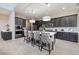 A bright kitchen features dark cabinets, an island with seating, and stainless steel appliances at 12 Hilltop Crest St, Henderson, NV 89011