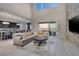 Spacious living room featuring a stone accent wall, high ceilings, and a seamless flow into the kitchen at 12 Hilltop Crest St, Henderson, NV 89011