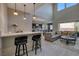 Open-concept living space flowing into the kitchen, featuring a comfortable seating area and a breakfast bar at 12 Hilltop Crest St, Henderson, NV 89011