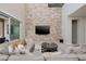 Stylish living room with a sleek stone wall, sectional sofa, and sliding glass doors at 12 Hilltop Crest St, Henderson, NV 89011