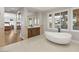 This bathroom features dual vanities, a free-standing tub with views, and an entryway to the bedroom at 1312 Enchanted River Dr, Henderson, NV 89012