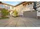 Large driveway leading to a garage and home exterior with stone accents and landscaping at 1312 Enchanted River Dr, Henderson, NV 89012