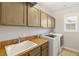 The functional laundry room features tile countertops, a sink and newer washer and dryer at 1312 Enchanted River Dr, Henderson, NV 89012