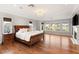 Spacious main bedroom featuring a fireplace, wood floors, and large windows providing lots of natural light at 1312 Enchanted River Dr, Henderson, NV 89012