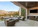 Entertaining outdoor patio with TV, kitchenette and furniture seating around a firepit at 1312 Enchanted River Dr, Henderson, NV 89012