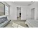 Minimalist bedroom features neutral tones, a cozy seating area, and a doorway view to another room at 136 Mosso Niente Pl, Henderson, NV 89011