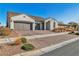 Charming single-story home with a three-car garage and brick-paved driveway at 136 Mosso Niente Pl, Henderson, NV 89011