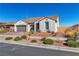 Single-story home with three-car garage, neutral stucco, and desert landscaping at 136 Mosso Niente Pl, Henderson, NV 89011