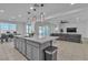 Open concept kitchen with a center island that includes bar seating, sink, and gray cabinets at 136 Mosso Niente Pl, Henderson, NV 89011