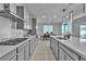 Well-equipped kitchen featuring an island with bar seating, quartz countertops, and stainless steel appliances at 136 Mosso Niente Pl, Henderson, NV 89011