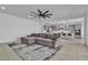 Spacious living room with a gray couch on stylish rug flowing into kitchen with large island and barstool seating at 136 Mosso Niente Pl, Henderson, NV 89011