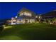 Expansive backyard with lush lawn, sparkling pool, and a contemporary home exterior against a twilight sky at 1786 Diamond Rim Ct, Henderson, NV 89012