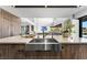 Modern kitchen island features a stainless steel sink, light countertops, and natural wood cabinets at 1786 Diamond Rim Ct, Henderson, NV 89012