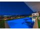 Beautiful infinity-edge pool with breathtaking city views at night and an adjacent outdoor kitchen at 1786 Diamond Rim Ct, Henderson, NV 89012