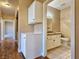 Hallway leading to the main bath with tiled floor, vanity, toilet, and good lighting at 1851 Hillpointe Rd # 2124, Henderson, NV 89074