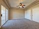 Spacious bedroom with tray ceiling, ceiling fan, carpet flooring, and large sliding glass doors to the outside at 1851 Hillpointe Rd # 2124, Henderson, NV 89074