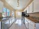 Modern kitchen featuring stainless steel appliances, granite countertops, and tile flooring, bathed in natural light at 1851 Hillpointe Rd # 2124, Henderson, NV 89074