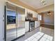 Modern kitchen featuring stainless steel appliances, tile flooring, and a view into the adjacent living room at 1851 Hillpointe Rd # 2124, Henderson, NV 89074