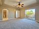 Spacious bedroom with carpet, ceiling fan, and sliding glass doors to balcony, featuring ensuite bathroom and neutral paint tones at 1851 Hillpointe Rd # 2124, Henderson, NV 89074