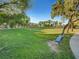 A picturesque park features a lush green lawn, mature trees, and a serene blue bench at 1851 Hillpointe Rd # 2124, Henderson, NV 89074