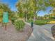 Park sign with path and benches surrounded by green grass and desert landscaping at 1851 Hillpointe Rd # 2124, Henderson, NV 89074