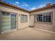 A cozy corner patio featuring a sliding glass door, window, and entry door with desert-toned stucco and a tile roof at 1851 Hillpointe Rd # 2124, Henderson, NV 89074