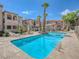 Wide angle of a community pool showing pool furniture and desert landscaping at 1851 Hillpointe Rd # 2124, Henderson, NV 89074