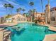 View of a community pool with decorative rock waterfall and desert landscaping at 1851 Hillpointe Rd # 2124, Henderson, NV 89074