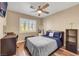 Cozy bedroom with desk, storage shelf, ceiling fan, and a large window at 2737 Sunrise Day Ct, Las Vegas, NV 89142