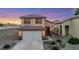 Front exterior featuring a two-story home with an attached garage and low maintenance desert landscaping at 2737 Sunrise Day Ct, Las Vegas, NV 89142