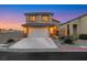 Two-story home with a two-car garage, simple landscaping, and a driveway for convenient parking at 2737 Sunrise Day Ct, Las Vegas, NV 89142