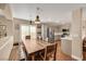 Open-concept kitchen and dining area featuring stainless steel appliances, shaker cabinets, and a large wooden dining table at 2737 Sunrise Day Ct, Las Vegas, NV 89142