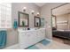 Bright bathroom featuring a double vanity with white cabinets and framed mirrors, adjacent to the bedroom at 2987 Matese Dr, Henderson, NV 89052