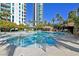 Large swimming pool with waterfall feature, tall palms, and clear blue sky at 322 Karen Ave # 1101, Las Vegas, NV 89109