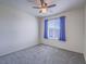 Cozy bedroom with neutral carpet, ceiling fan, and a bright window at 4550 Kali Lyn St, North Las Vegas, NV 89031