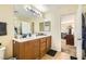 Bathroom featuring double sinks, a large mirror and wood cabinets at 5329 Fireside Ranch Ave, Las Vegas, NV 89131