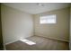 A bright bedroom with a window letting in natural light and neutral colored carpet at 5732 Heron Ave, Las Vegas, NV 89107