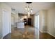 Spacious dining area showcasing a modern light fixture, a functional kitchen, and plenty of natural light at 5732 Heron Ave, Las Vegas, NV 89107