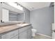 Bathroom featuring gray vanity, sink, and toilet with shelf at 584 Sellers Pl, Henderson, NV 89011