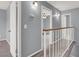 Upstairs hallway featuring a railing and three doorways at 584 Sellers Pl, Henderson, NV 89011