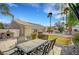 This backyard features an outdoor dining area, barbeque, refreshing pool, and mature landscaping at 6105 Port Of Dreams Dr, Las Vegas, NV 89130