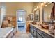 Bathroom featuring dual vessel sinks with granite countertops, and a soaking tub at 6105 Port Of Dreams Dr, Las Vegas, NV 89130